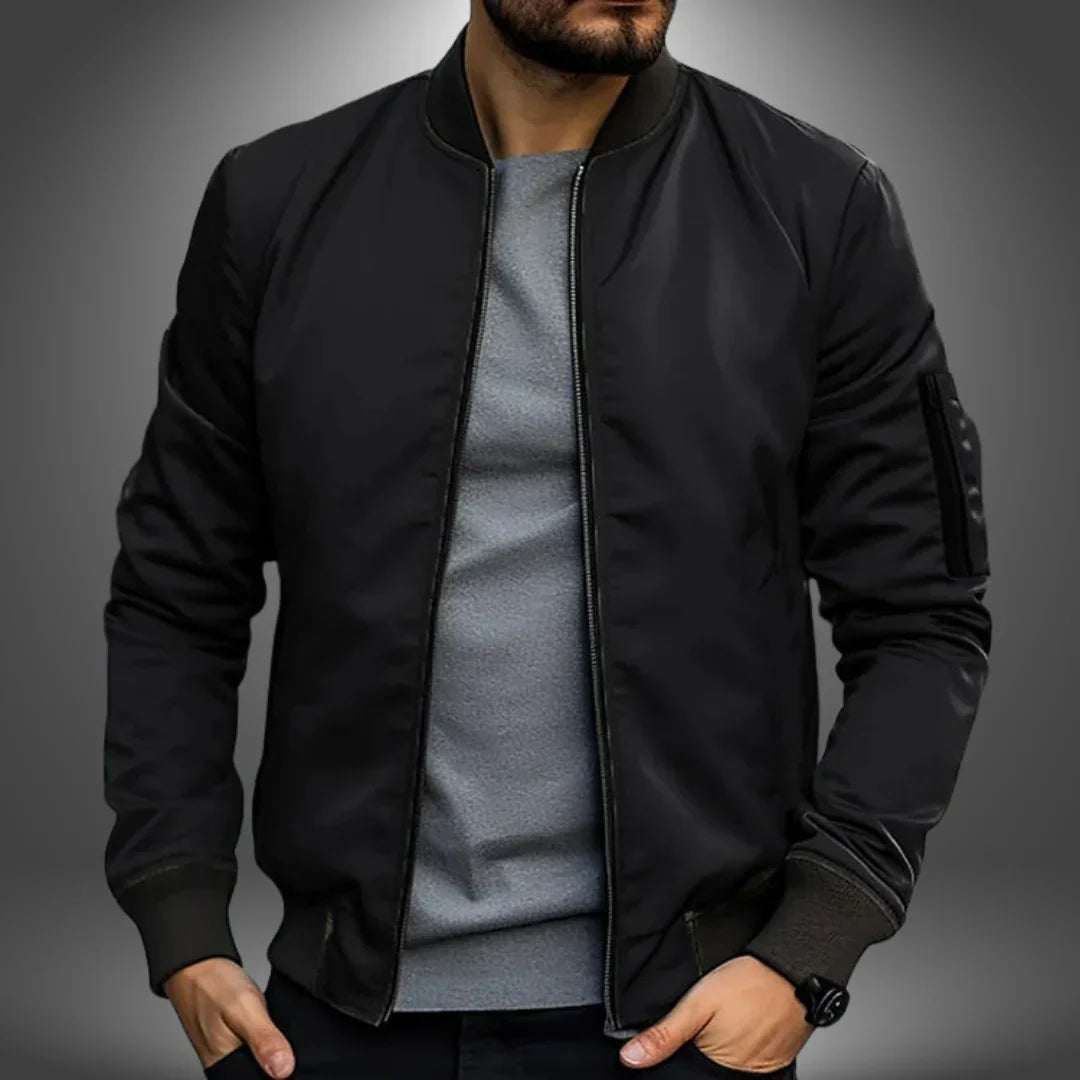 Black bomber jacket worn by a person on a gray background